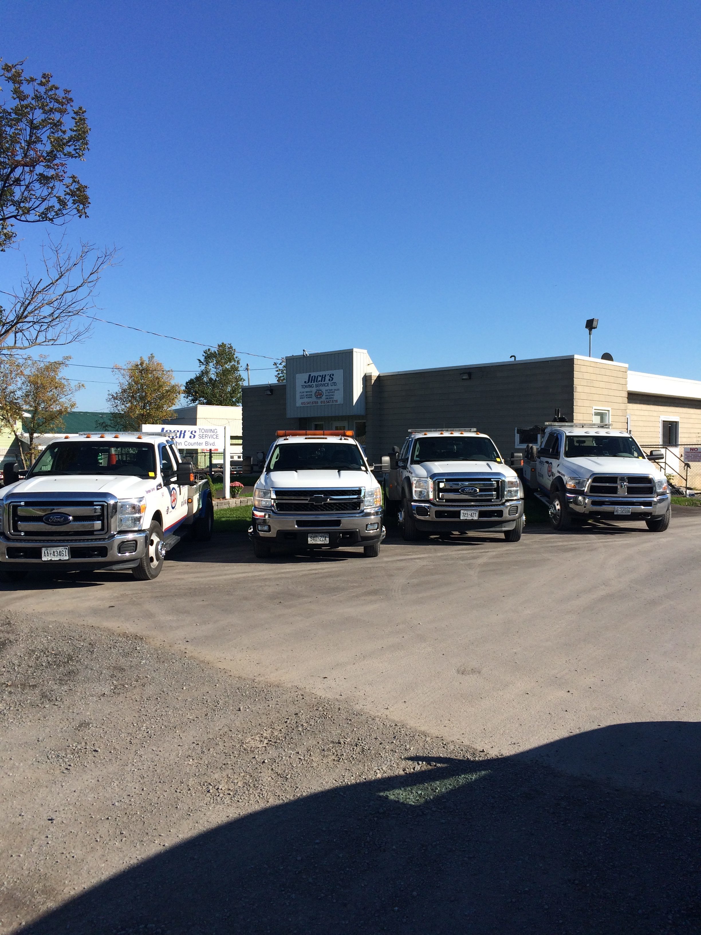 line-up of Jack's Towing vehicles in front of building