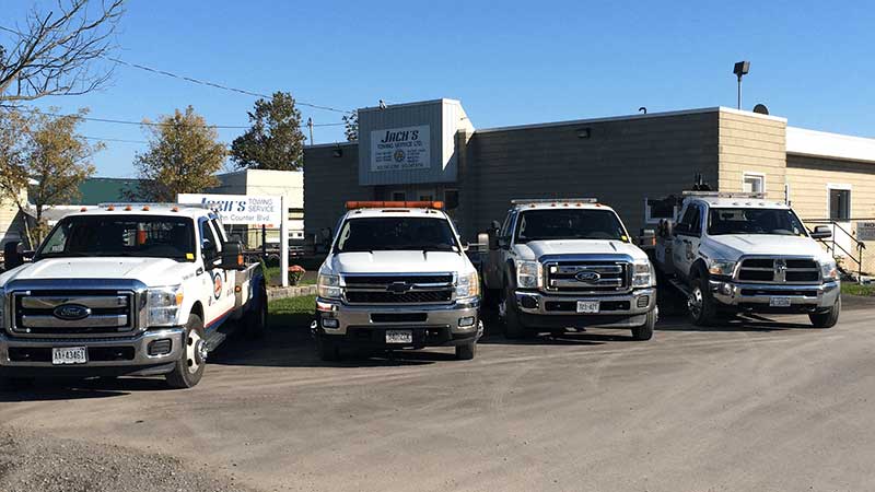 line-up of Jack's Towing vehicles in front of building