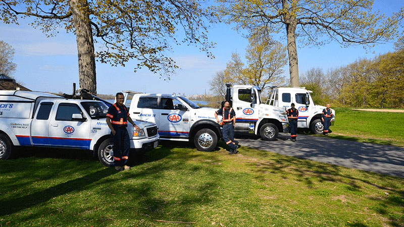 line-up of Jack's Towing vehicles with drivers standing beside them