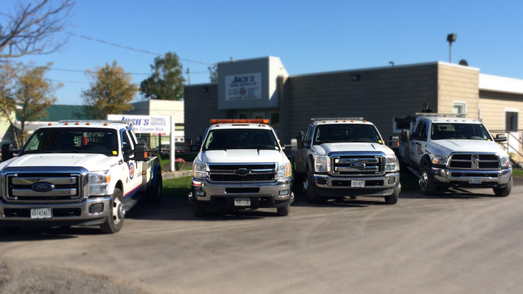 line-up of Jack's Towing vehicles in front of building